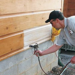 Man Applying Stain to Wood Siding